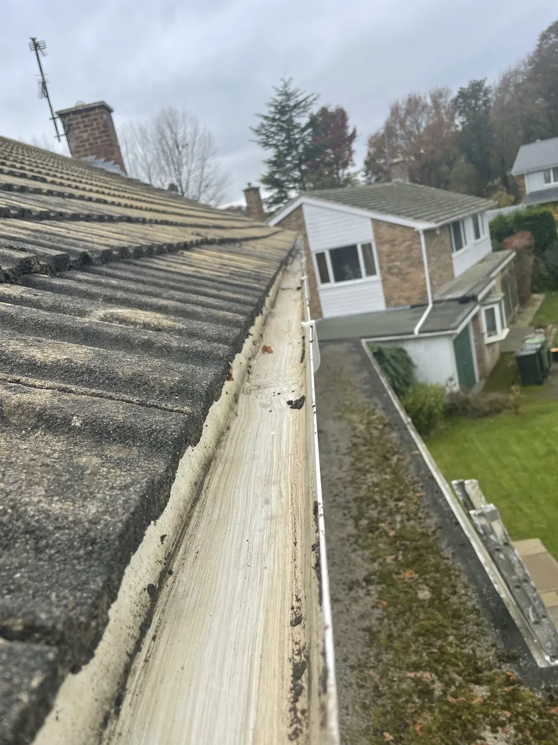 The same white gutter with the leaf build-up removed